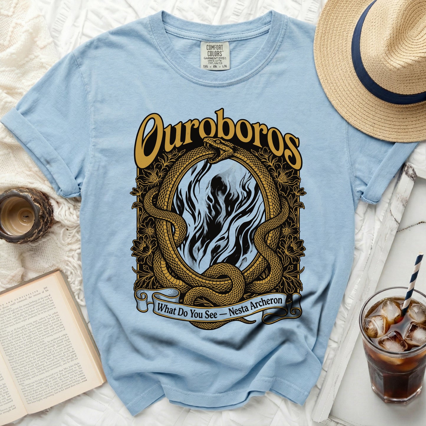 Light blue t-shirt with gold Ouroboros snake graphic and text.