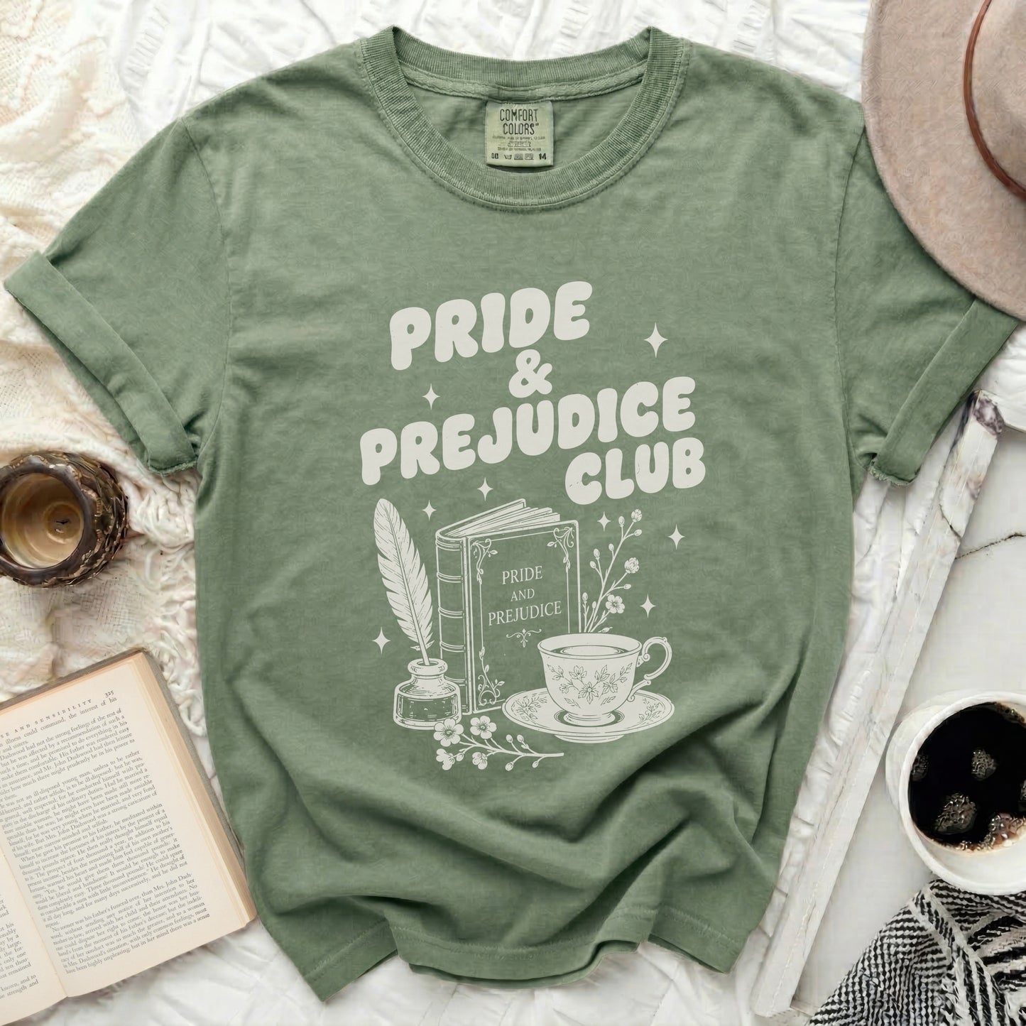 Green t-shirt with "Pride & Prejudice Club" text and book icons.