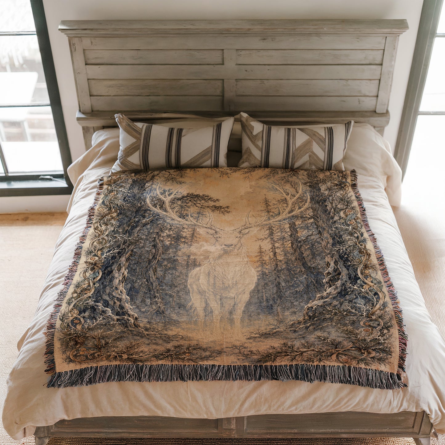 a bed with a large, intricately designed blanket featuring a deer in a forest setting. The blanket is spread out on the bed, covering the entire surface.