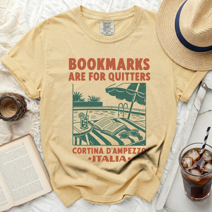Yellow t-shirt with "Bookmarks are for Quitters" text and Italian destination graphic.