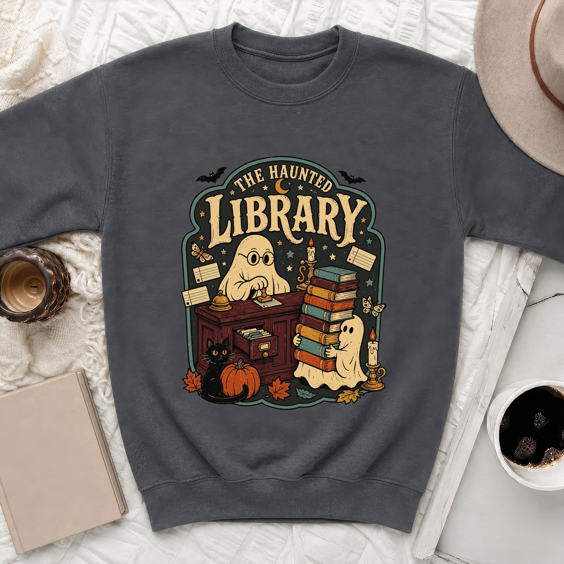 Dark gray sweatshirt featuring a "The Haunted Library" design with ghosts, books, and Halloween elements.