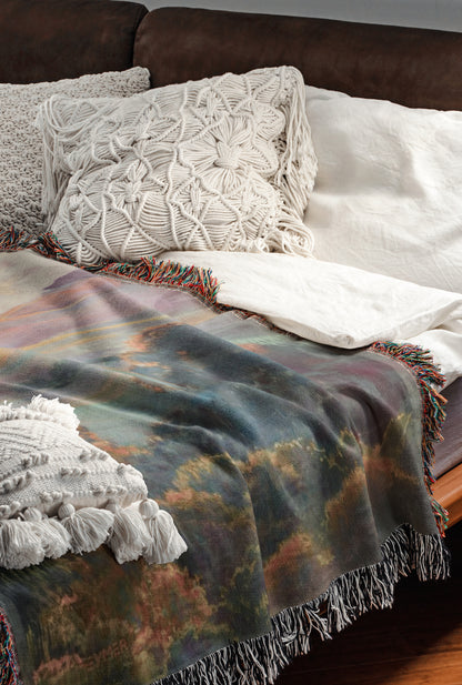 a cozy and inviting bedroom scene, featuring a bed with a colorful blanket and a white pillow, as well as a brown leather couch.