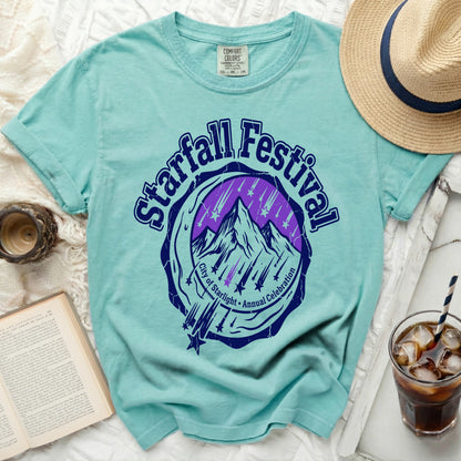 Teal t-shirt with Starfall Festival graphic of mountains and stars.
