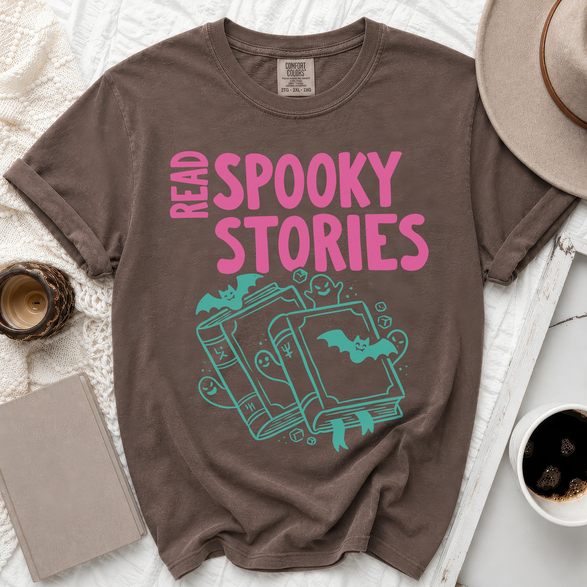 Brown t-shirt with pink text "READ SPOOKY STORIES" and teal book graphics.