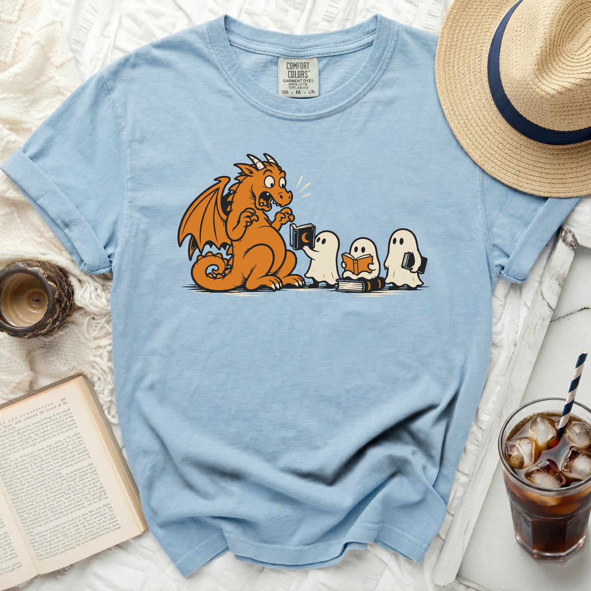 Light blue t-shirt with dragon and ghosts reading books graphic.