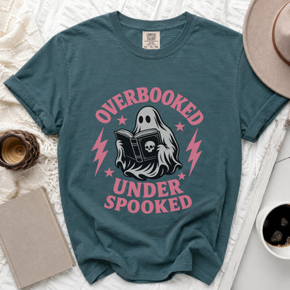 Teal t-shirt with ghost reading a book graphic that says "Overbooked Under Spooked".