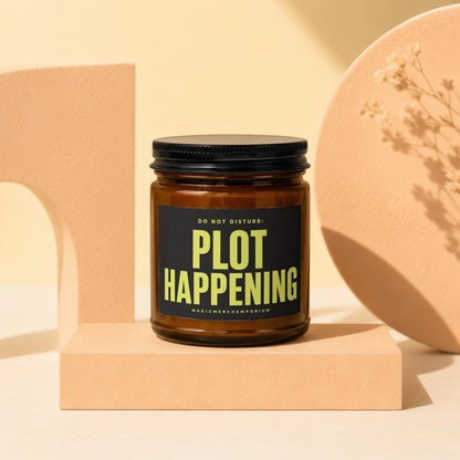 Amber glass candle with black lid reads "DO NOT DISTURB: PLOT HAPPENING"
