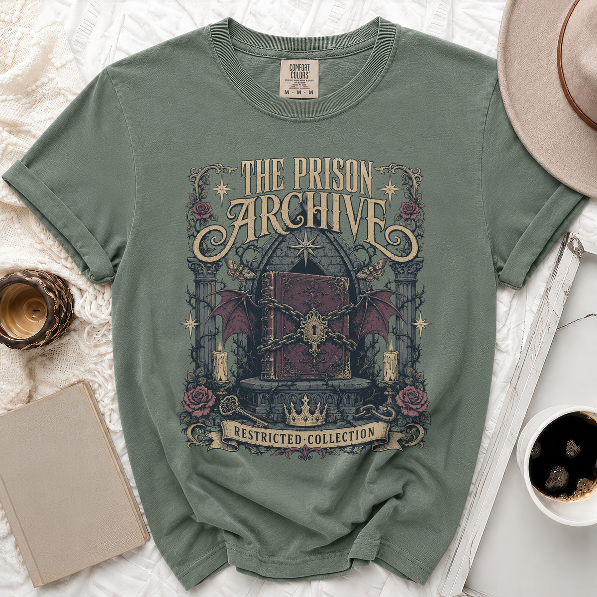 Green t-shirt with "The Prison Archive Restricted Collection" text and gothic book design.