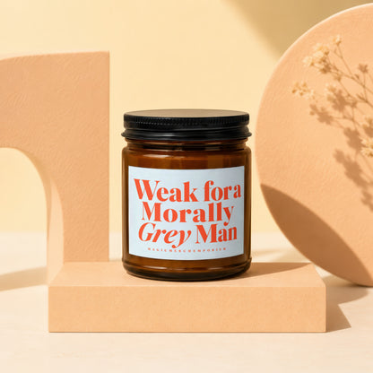 Amber glass candle in geometric display with text "Weak for a Morally Grey Man".