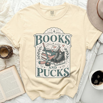 Comfort Colors t-shirt with "Books and Pucks" text, hockey gear, and ice skates.