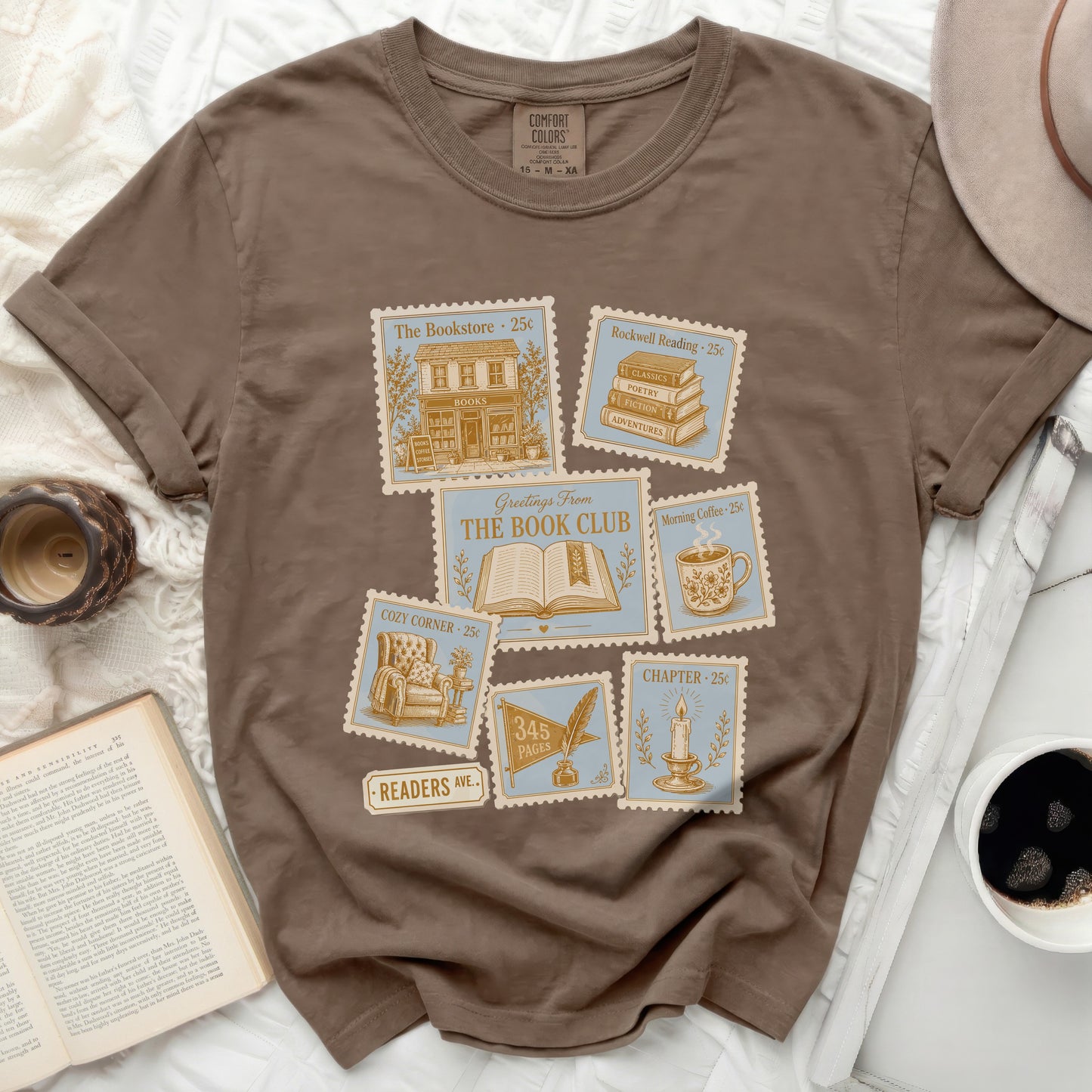 Brown t-shirt with vintage stamp graphics featuring books and coffee.
