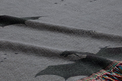 a close-up view of a textured fabric with a bat pattern, featuring a dark bat silhouette against a lighter background.