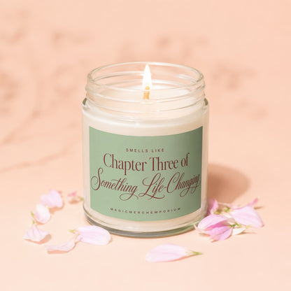 Cream candle in glass jar with lit wick, "Chapter Three of Something Life-Changing" label.