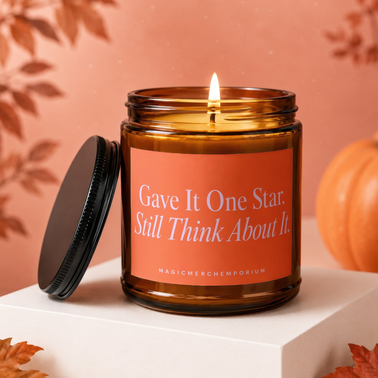 Brown glass candle with orange label reading "Gave It One Star. Still Think About It."