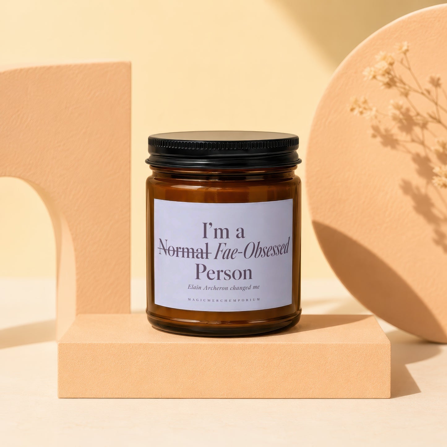 Amber jar candle with black lid and label reading "I'm a Normal Fae-Obsessed Person".