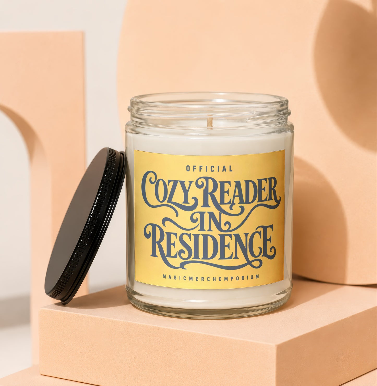 Candle with yellow label reading "Official Cozy Reader in Residence"