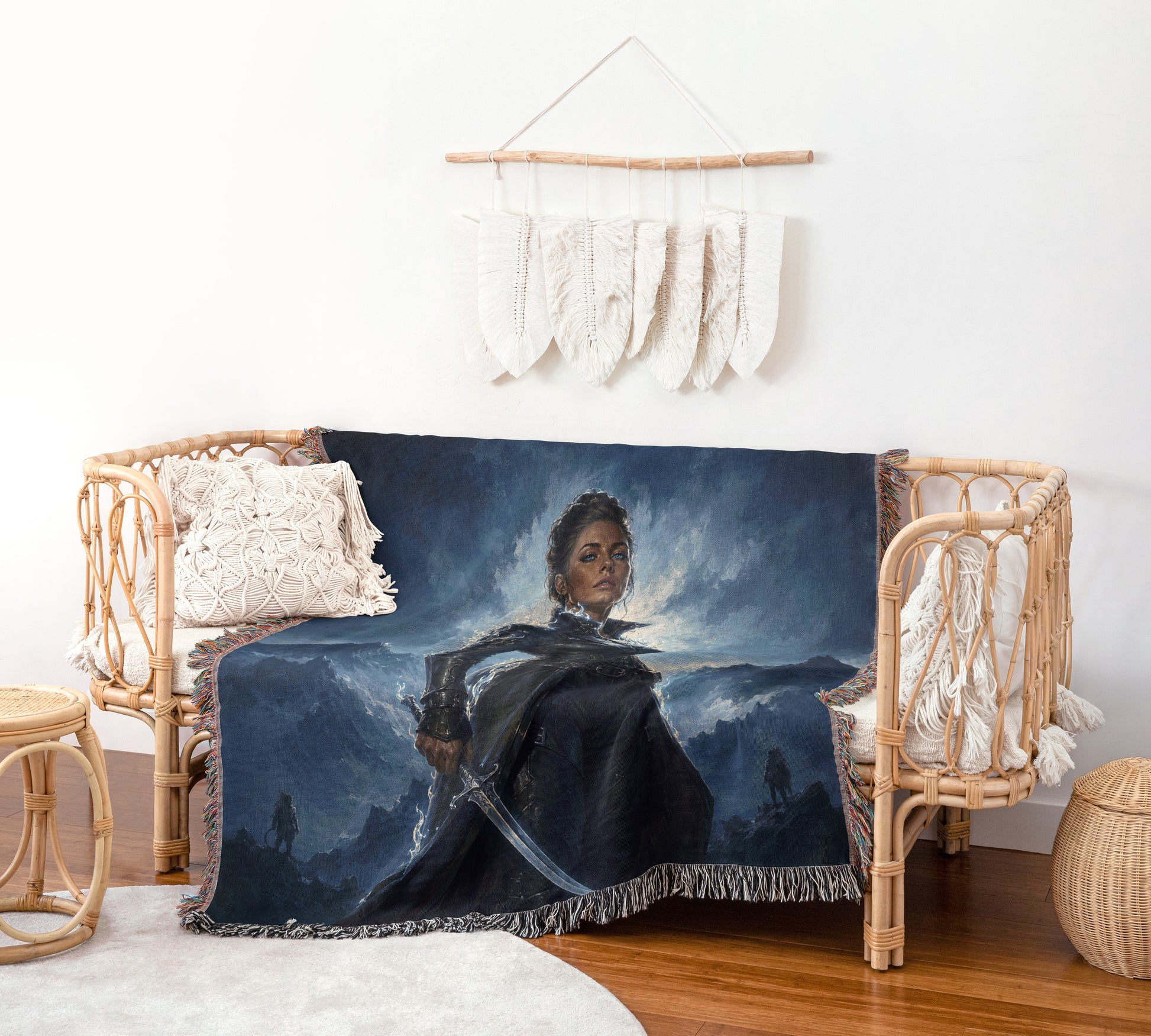 a cozy living room setting with a woven bench and a woven chair. The bench is adorned with a large woven blanket that depicts a woman in a dark outfit, holding a sword and standing in front of a stormy landscape. The chair is also covered with a similar blanket, creating a harmonious and visually appealing arrangement.