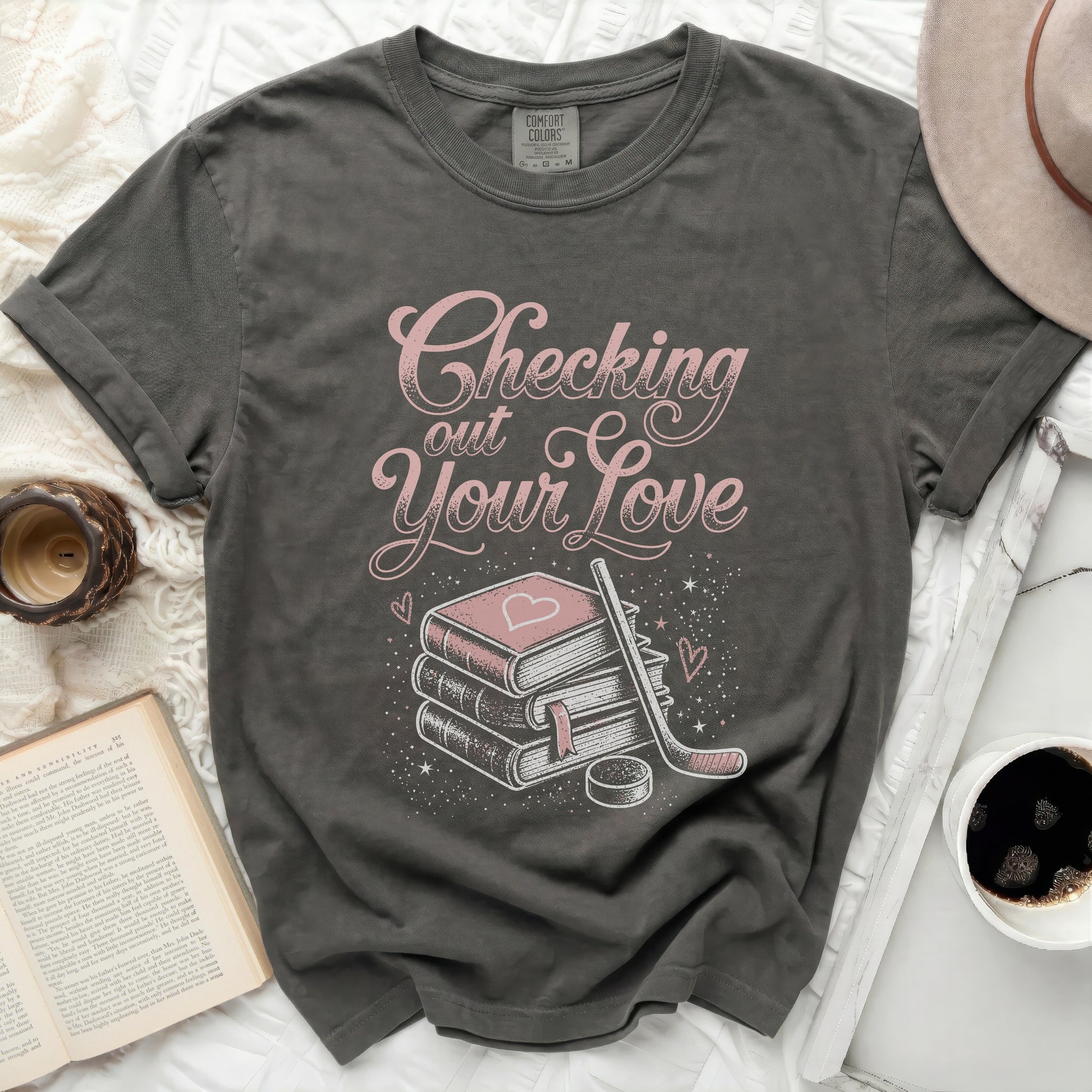 Dark gray t-shirt with "Checking out Your Love" text and book, hockey stick, and heart graphic.