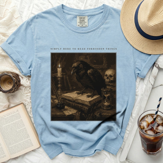 Light blue t-shirt with raven illustration and text "SIMPLY HERE TO READ FORBIDDEN THINGS".