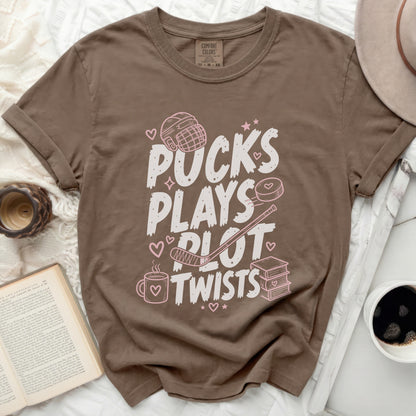 Brown t-shirt with "Pucks Plays Plot Twists" and hockey graphics.