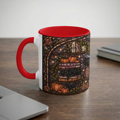 White mug with stained glass design of black cat, pumpkins, and books.