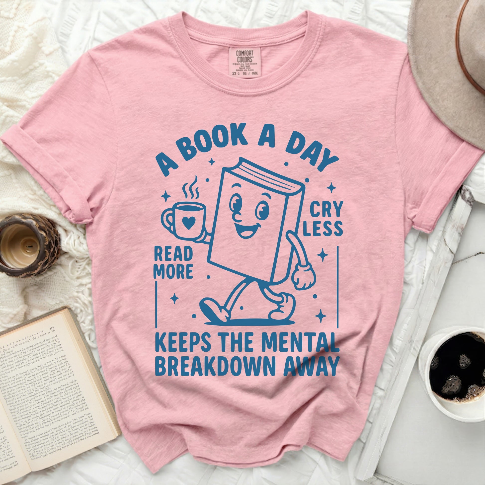 Pink t-shirt with "A book a day read more cry less keeps the mental breakdown away" graphic.