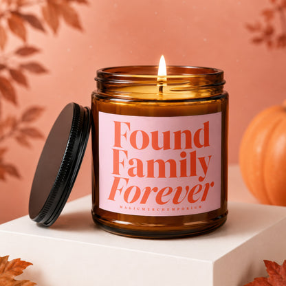 Amber candle with "Found Family Forever" in orange text on a pink label.