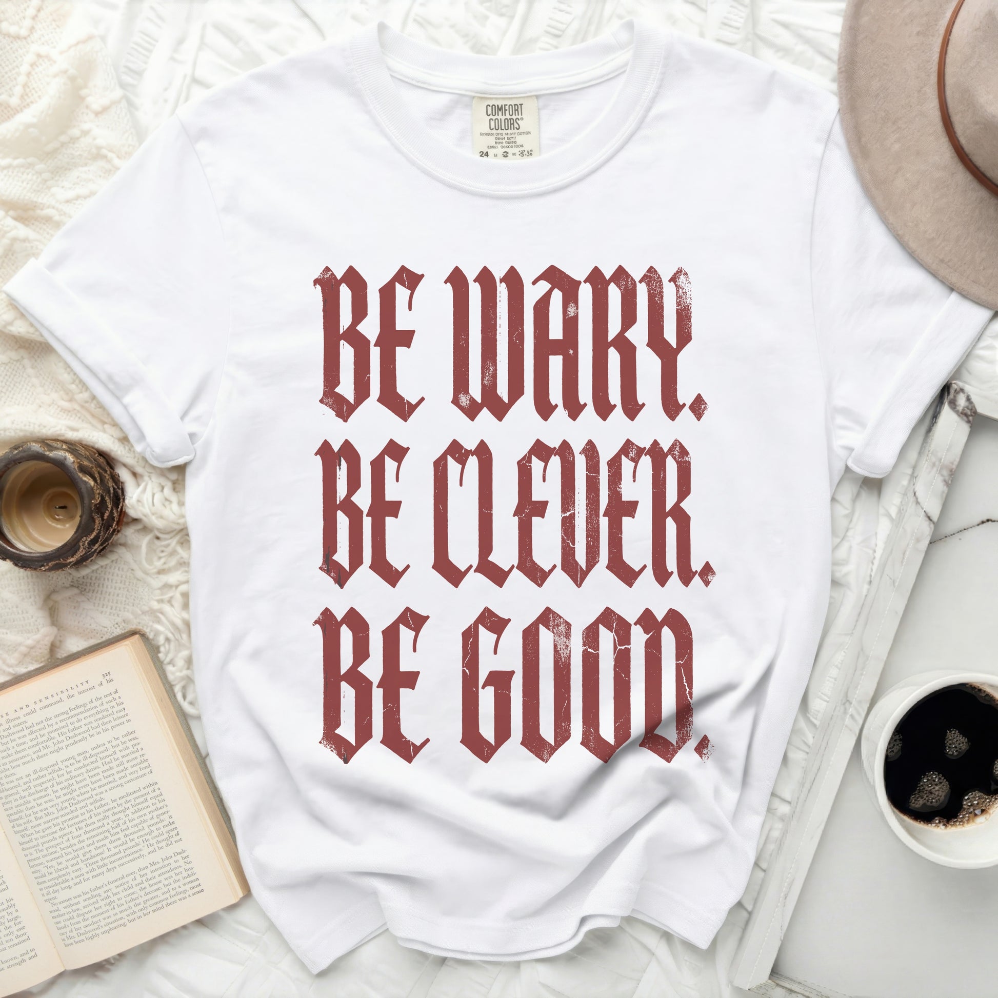 White t-shirt with red distressed text reading "BE WARY. BE CLEVER. BE GOOD."