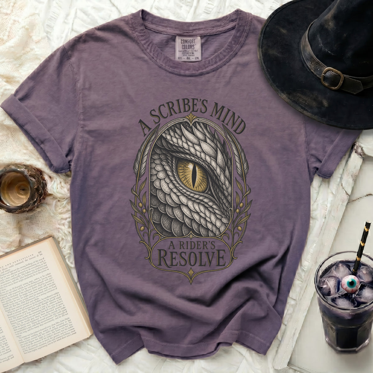 Purple t-shirt with a dragon eye graphic and text "A Scribe's Mind A Rider's Resolve".