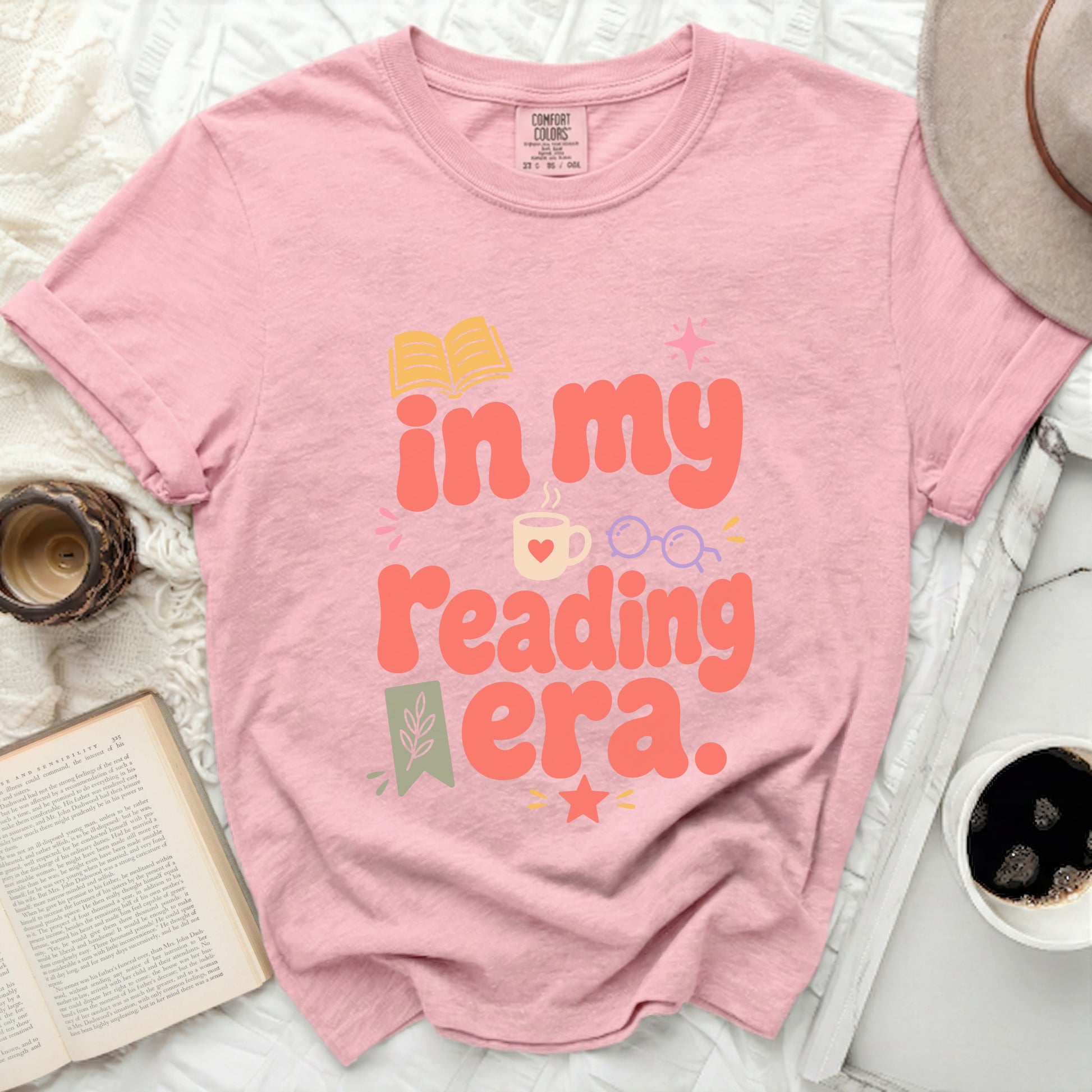 Pink t-shirt with "in my reading era" text and book graphics.