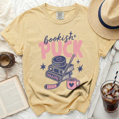 Yellow t-shirt with "bookish+ puck" text and hockey graphics.