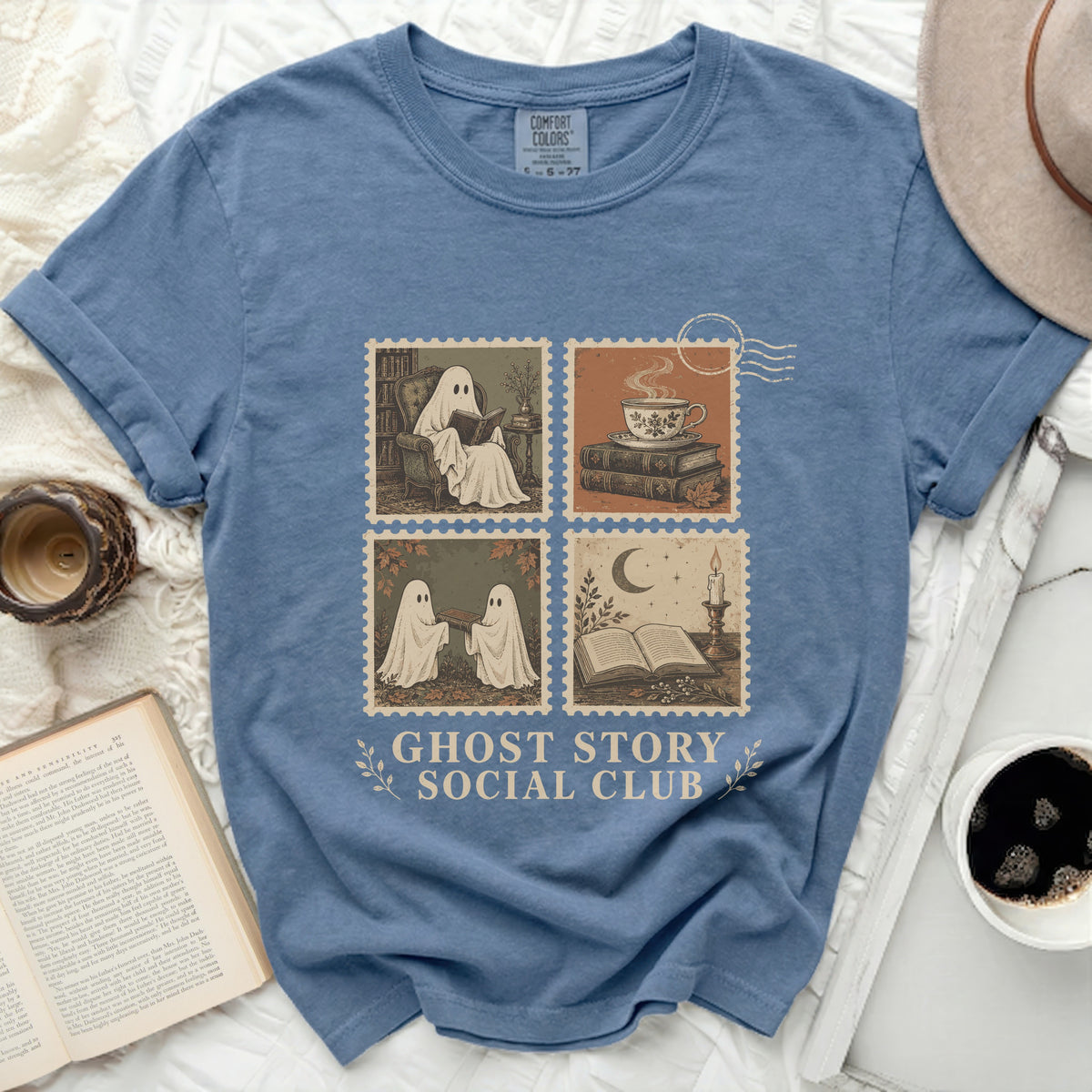 Blue t-shirt with ghost illustrations in four stamp panels and "Ghost Story Social Club" text.