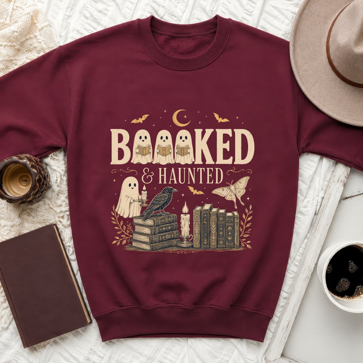 Maroon sweatshirt with the text "BAAAKED & HAUNTED" featuring ghosts and books.