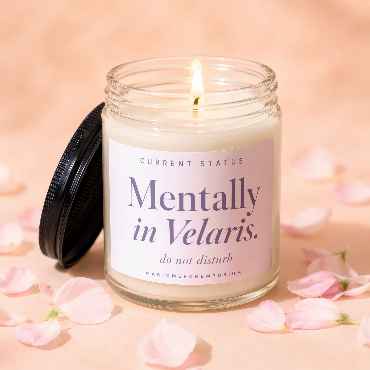Glass candle with lit wick, "Mentally in Velaris. do not disturb" text, and pink petals.