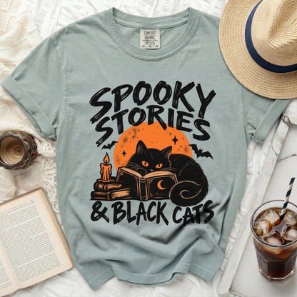 Light blue t-shirt with black graphic of a cat reading under an orange moon.
