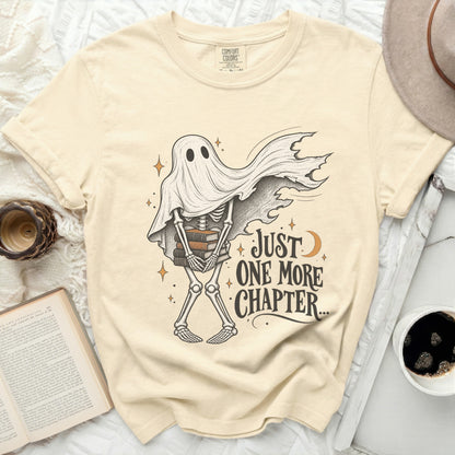 Skeleton ghost holding books, with text "Just One More Chapter".