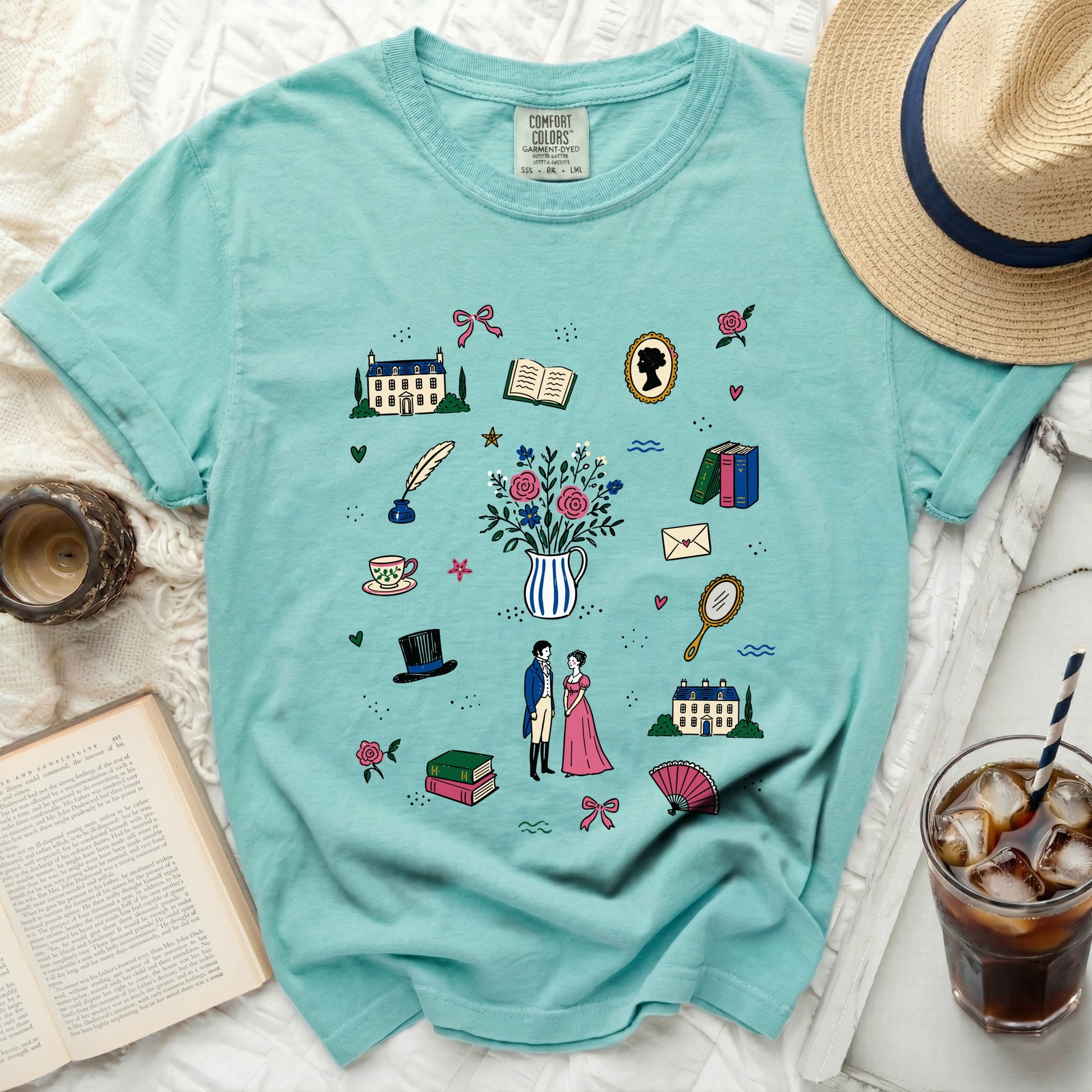 Teal t-shirt with a scattered pattern of historical illustrations and flowers.
