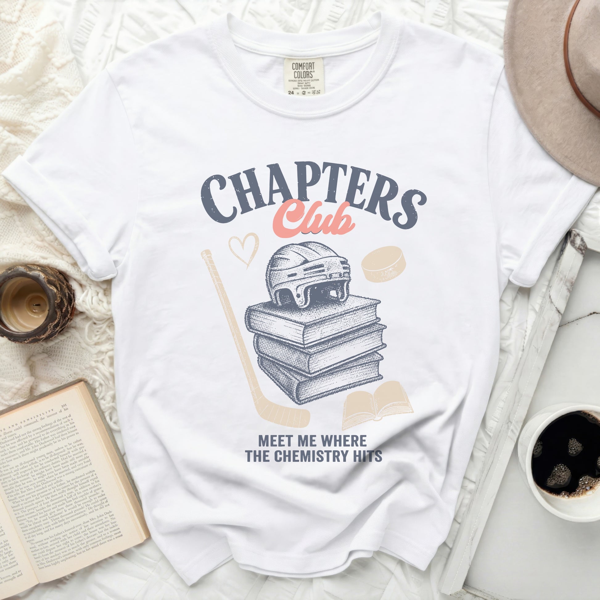 White t-shirt with "Chapters Club" text, stacked books, heart, and hockey gear.