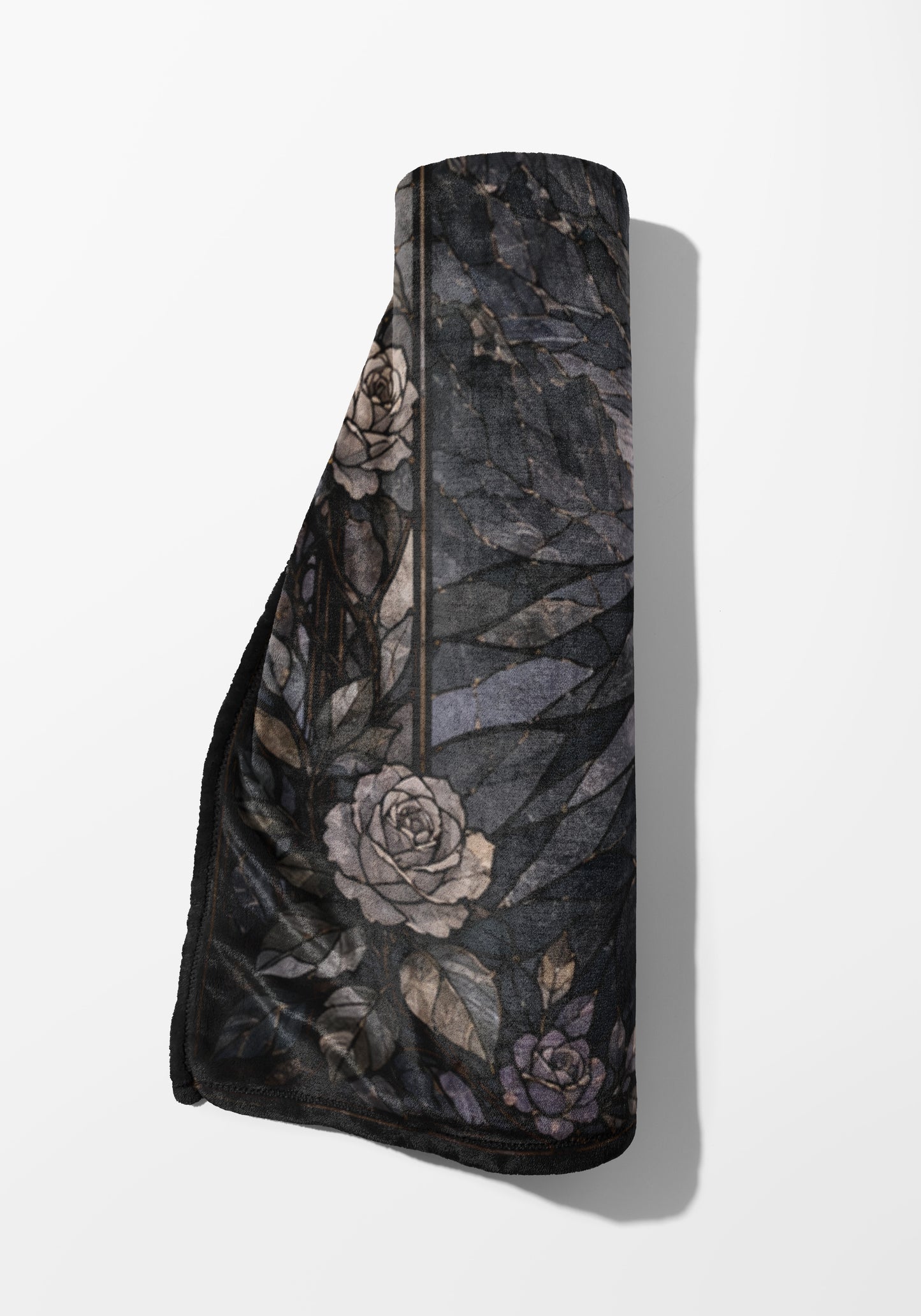 Rolled blanket with dark floral pattern featuring roses and leaves.