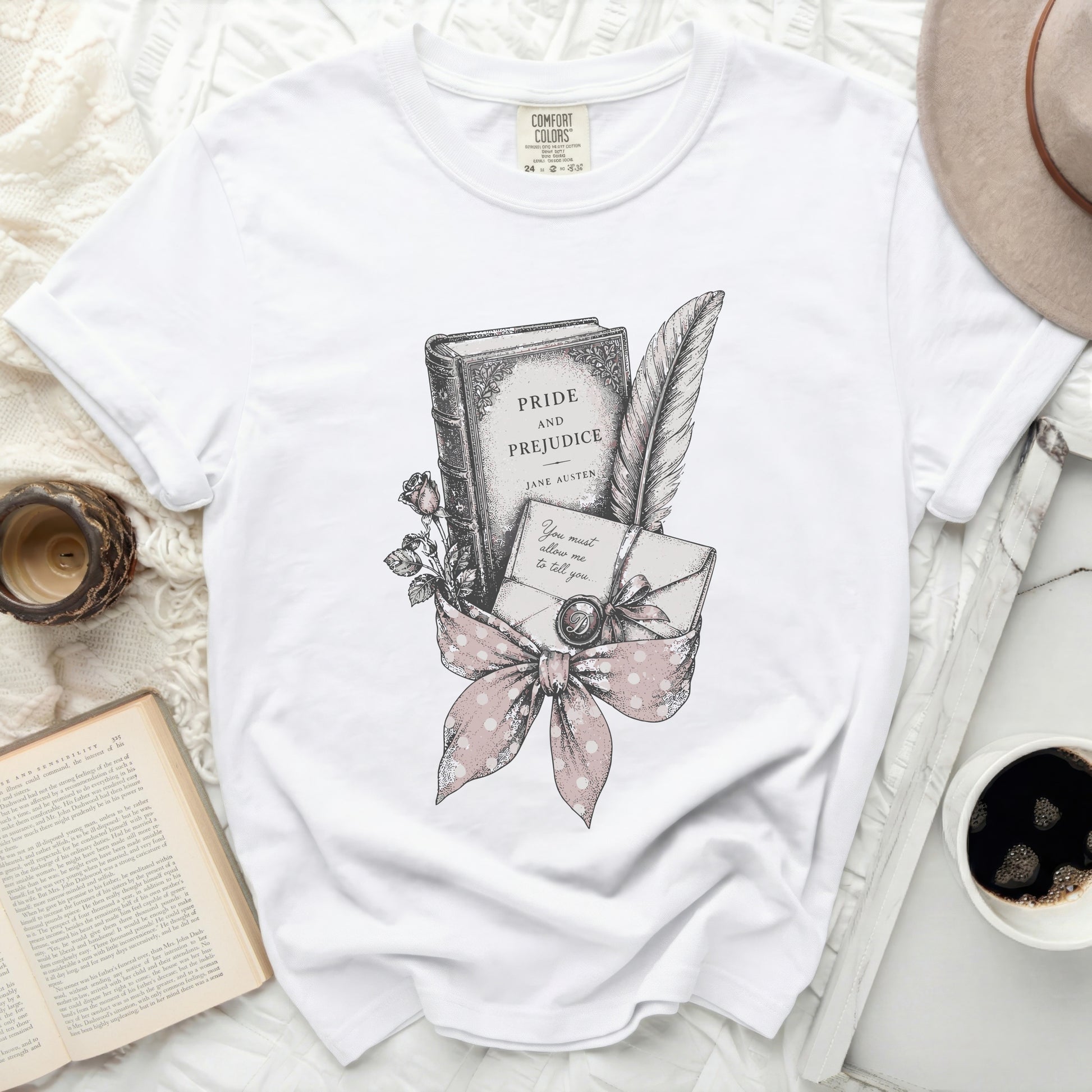 White t-shirt with Pride and Prejudice book, quill, and letter graphic.