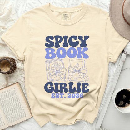 "Spicy Book Girlie Est. 2026" text on a cream colored t-shirt.
