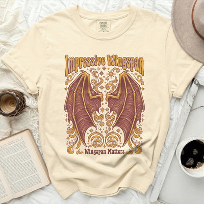 Impressive Wingspan graphic with bat wings and text, on a cream shirt.
