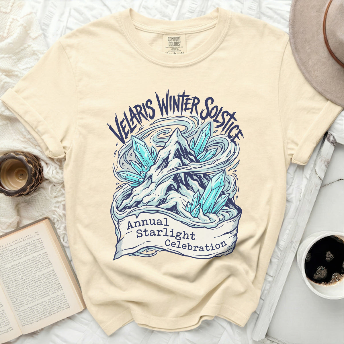Cream t-shirt with "Velaris Winter Solstice Annual Starlight Celebration" graphic.