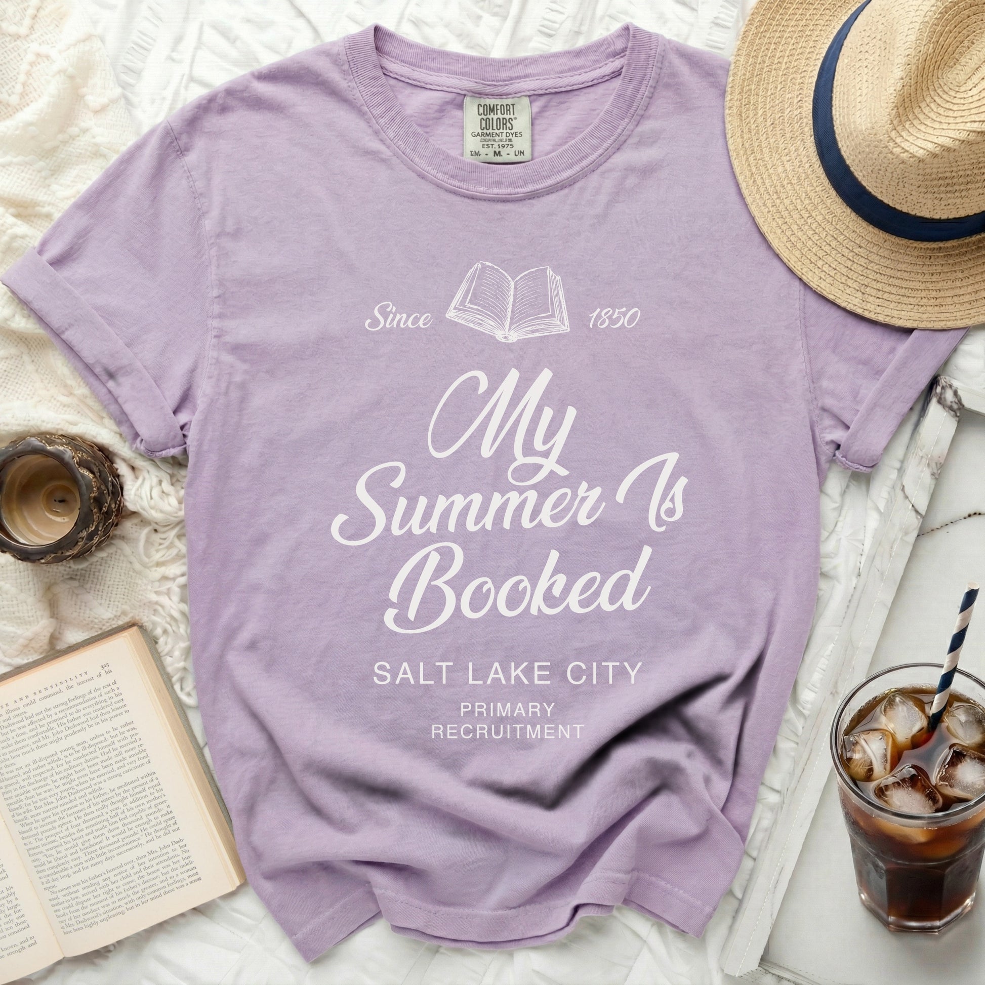 Lavender t-shirt with "My Summer Is Booked" text and book graphic.