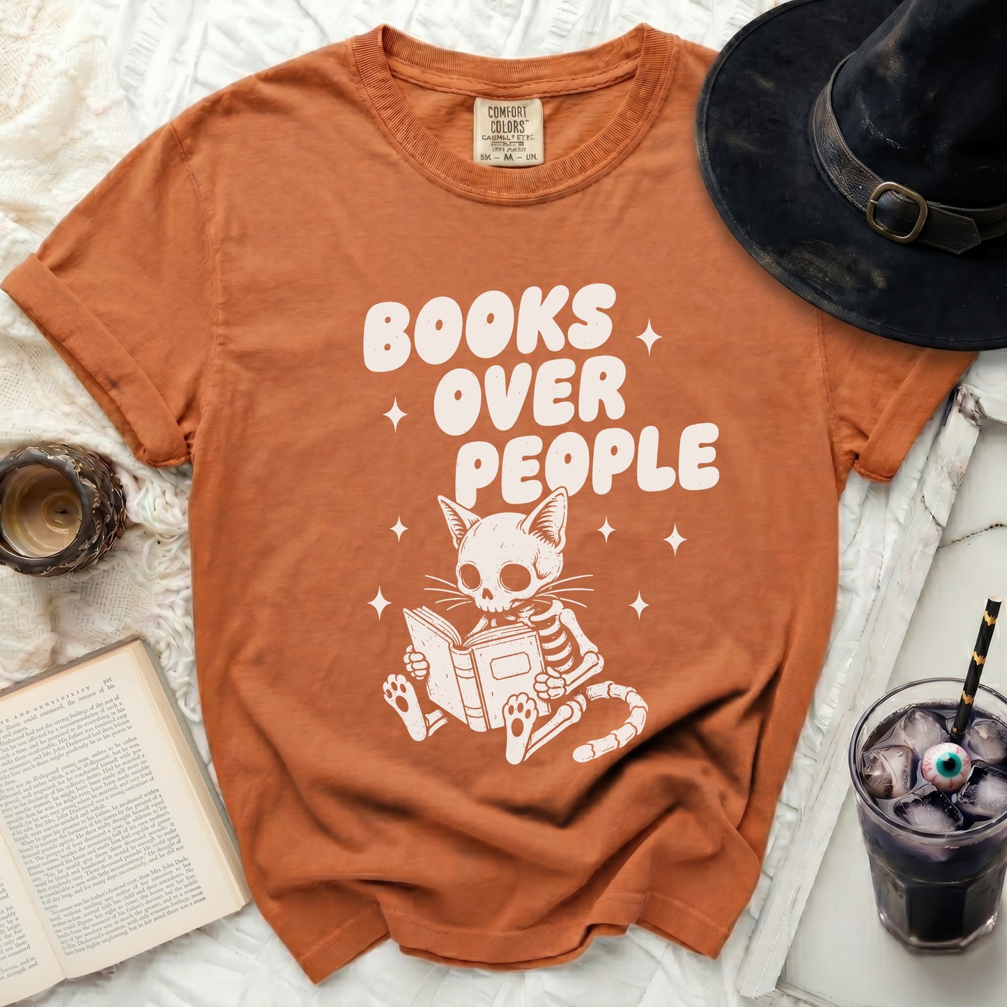 Orange comfort colors t-shirt with white text: Books Over People and skeleton cat reading.