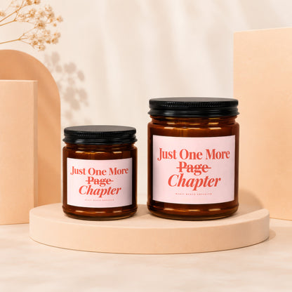 Two amber glass candles with pink labels reading "Just One More Page Chapter".