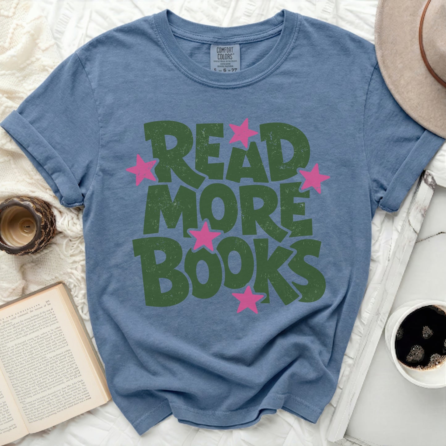 Blue t-shirt with green "READ MORE BOOKS" text and pink stars.