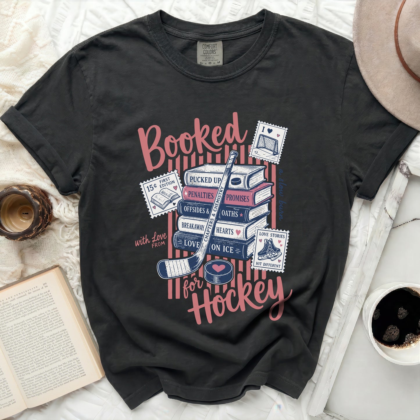 Dark t-shirt with "Booked for Hockey" text and hockey-themed stamps.