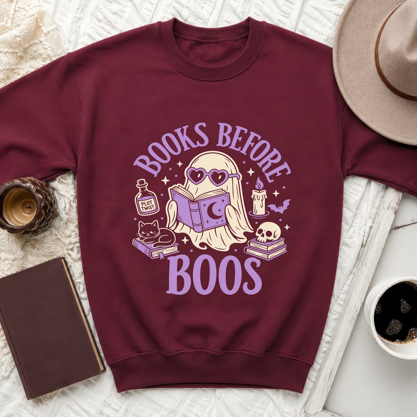 Maroon sweatshirt with graphic of ghost reading book, text "BOOKS BEFORE BOOS."