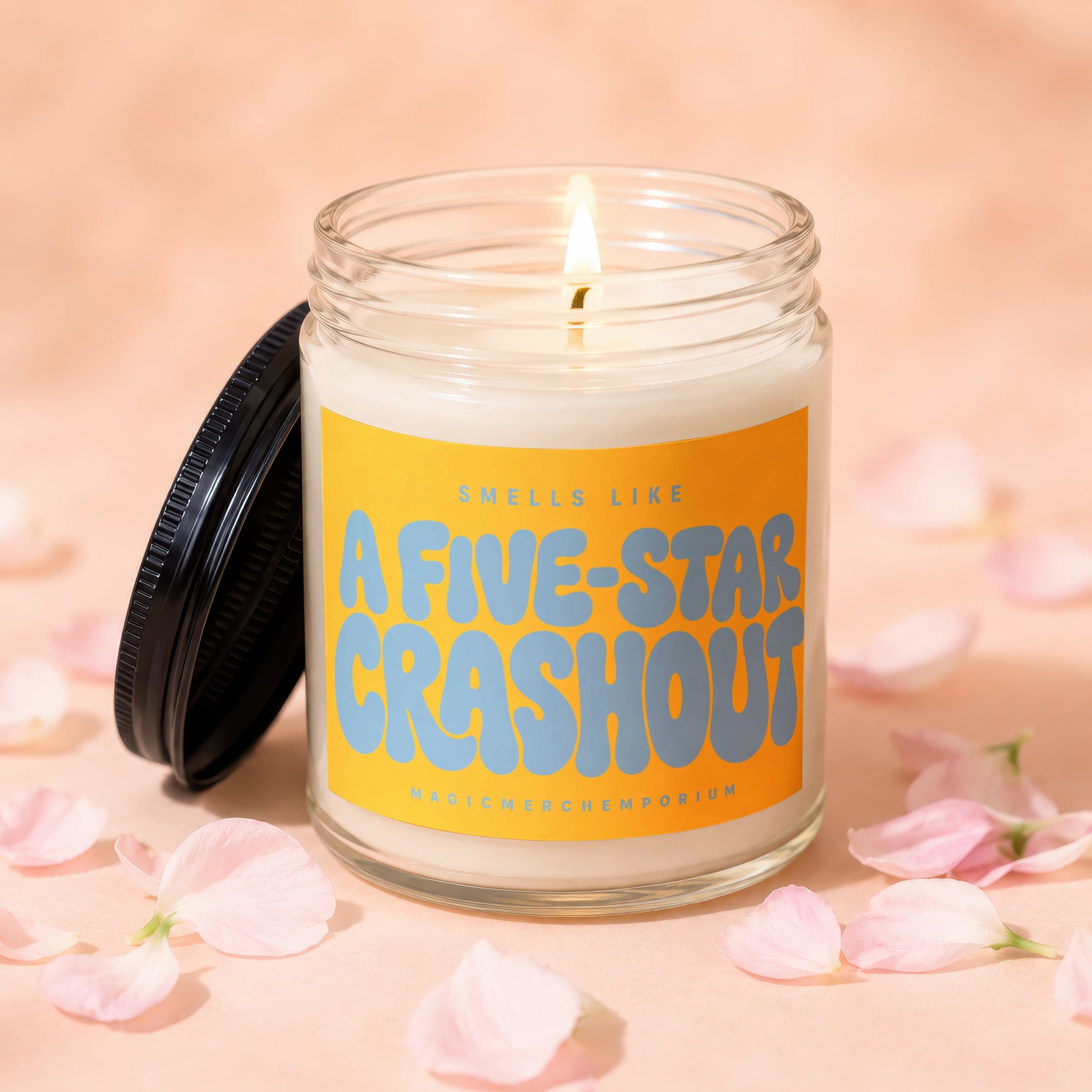 Lit candle in glass jar with "A FIVE-STAR CRASHOUT" on orange label.